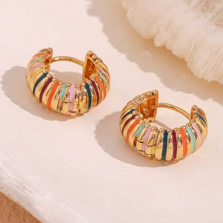 Detailed shot of the enamel rainbow hoop earrings, highlighting the smooth 18K gold plating.