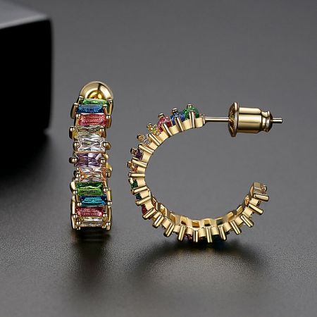 Close-up detail of the gold hoop earrings with multicolored baguette gemstones.