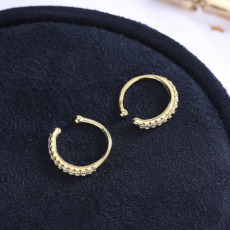 A pair of radiant gold ear cuffs adorned with shimmering stones.