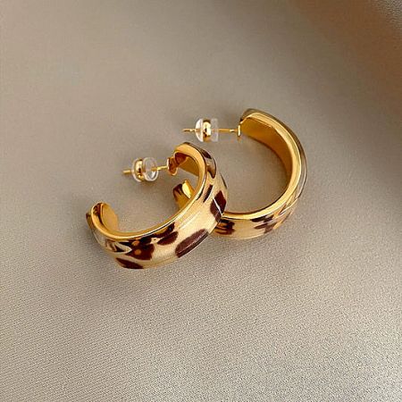Chunky gold hoop earrings with a fashionable tortoiseshell resin pattern.