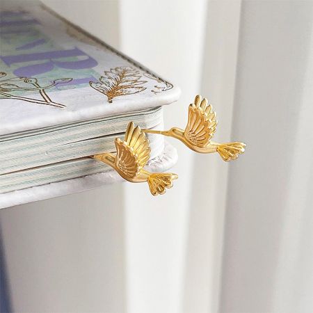 A pair of the 3D bee bird piercing stud earrings on a white background, highlighting the detailed craftsmanship.