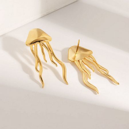 A detailed view of the pair of jellyfish earrings, showing their smooth finish and intricate tentacle design.