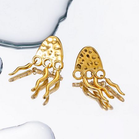 A pair of gold jellyfish earrings displayed to show their unique design and brilliant texture.