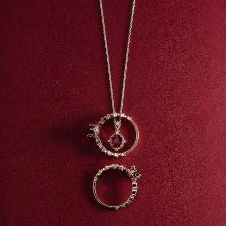 The vintage ruby pendant necklace displayed alongside a matching gold ring.