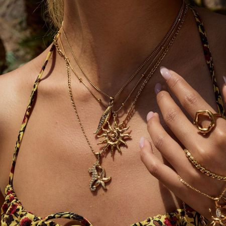 Minimalist styling of the 18k gold plated sun pendant necklace, perfect as a women's beachwear accessory.