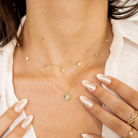 Detailed view of the North Star pendant alongside other gold jewelry.