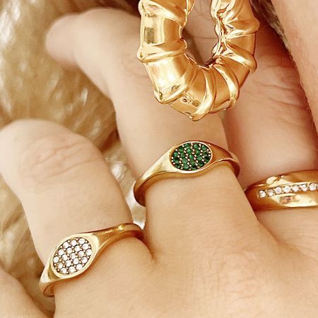 A collection of stainless steel jewelry including the zircon signet rings and a matching bracelet.