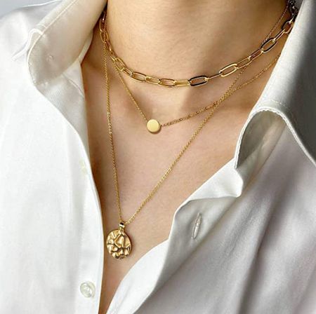 Model wearing the layered gold chain necklace to showcase its length and style.