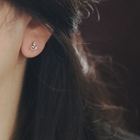 Model showcasing the elegant gold maple leaf stud earring.