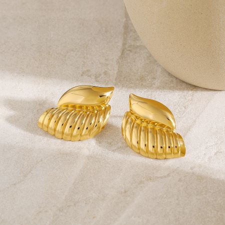 Detailed view of the gold conch shell stud earrings, highlighting the intricate design.