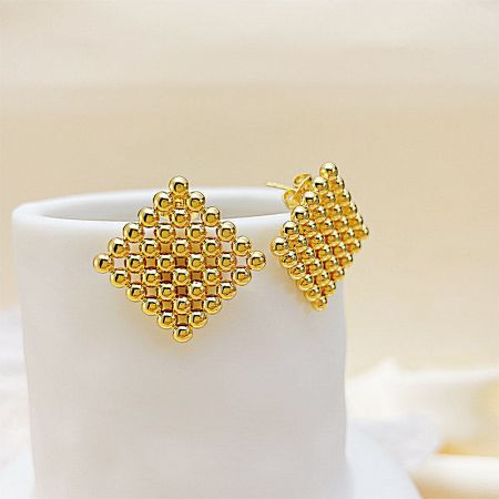 Close-up of the leaf-design gold stud earrings from the collection, featuring intricate beadwork.