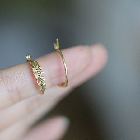 Detailed shot of the intricate feather and leaf motif on the sterling silver hoop earrings.