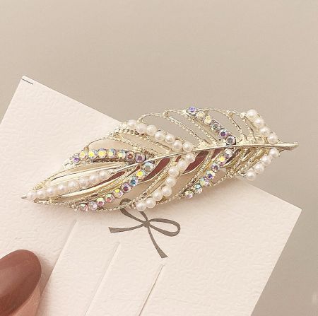 A detailed view of the Pearl Crystal Leaf Hair Clip, showing the intricate gold metalwork and placement of pearls and rhinestones.