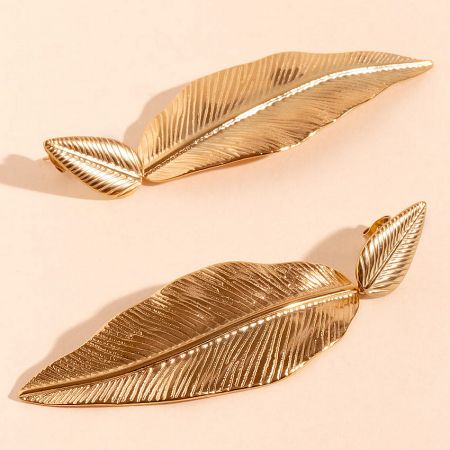 Detailed view of the gold leaf-shaped stainless steel earrings.