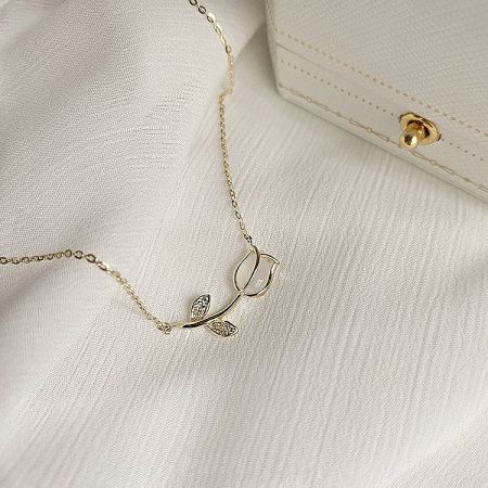 Chic gold-plated necklace with a double leaf pendant, one accented with a stone.