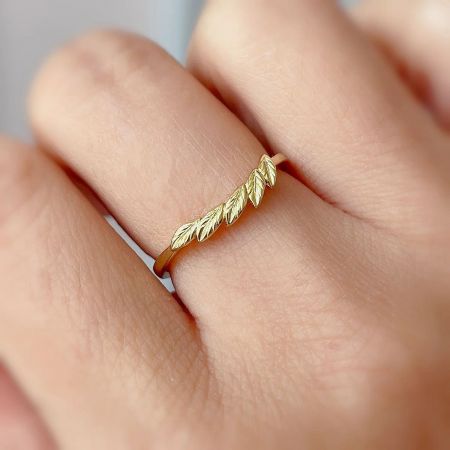 Close-up of the gold-plated leaf-shaped sterling silver ring worn on a finger, showcasing its delicate design.