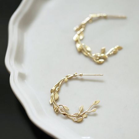 Another perspective of the gold leaf vine stud earrings, emphasizing their delicate and artistic design.