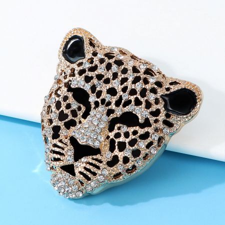 Detailed close-up of the gold leopard head brooch with sparkling rhinestones.
