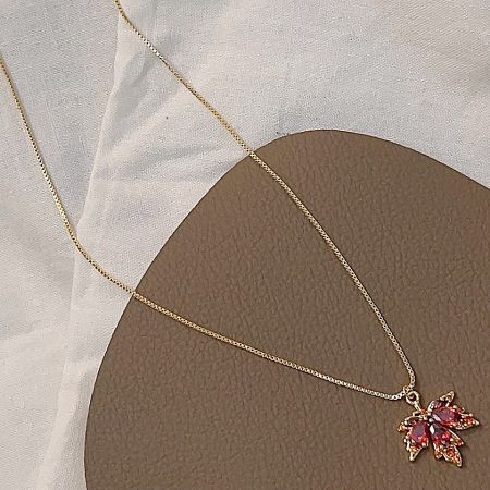 Another angle of the gold-plated necklace, showing the vibrant red and orange hues of the gemstones.