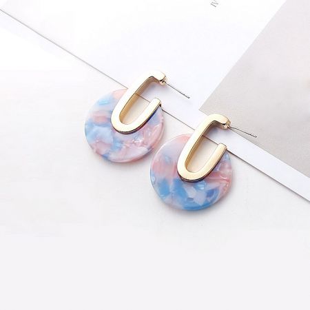 Close-up of the gold-plated brass and marbled resin construction of the hoop earrings.