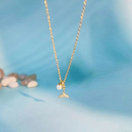 The complete gold mermaid tail necklace with its pearl charm.