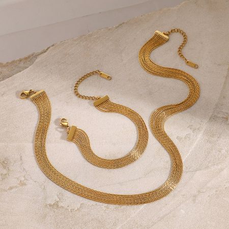 Close-up view of the intricate gold mesh texture of the stackable necklace and bracelet set.