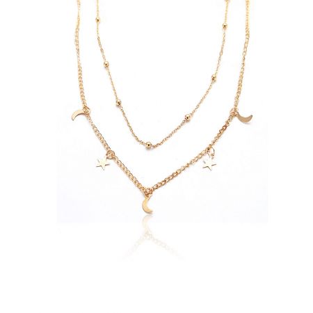 Close-up view of the two layered gold necklaces with moon and star charms.