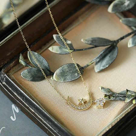 Gold star and moon pendant necklace elegantly displayed in a gift box, highlighting its fine craftsmanship.