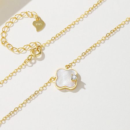 A styled shot of the four-leaf clover necklace paired with a matching bracelet, showcasing a complete jewelry set.