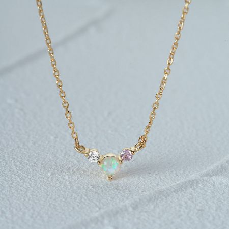 Another design from the necklace set, featuring a gold chain with an opal and gemstone pendant.