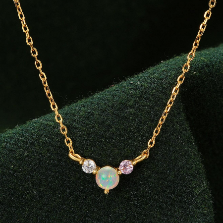 Close-up of a gold necklace with a stunning opal and gemstone pendant from the collection.