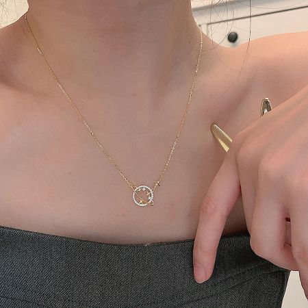 Close-up of the planet pendant with white stone accents resembling a shooting star.