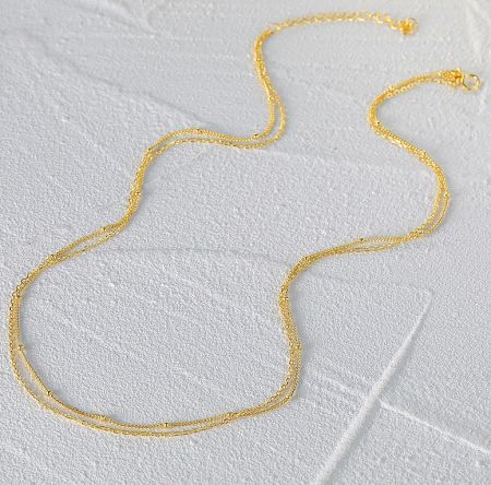 Close-up of the gold plated chain necklace against a white background