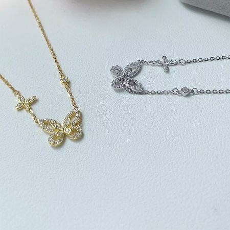 Gold-plated butterfly necklace and matching silver butterfly bracelet, showcasing versatile design options.