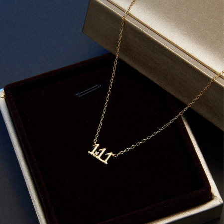 925 Sterling Zilver Goudkleurige Geluksengel Nummer Ketting Set - Close-up van een 925 sterling zilveren, goudkleurige ketting met een delicate '111' engel nummer hanger op een witte achtergrond.