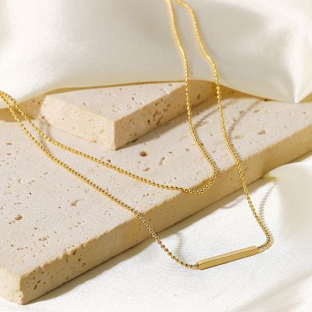 Front view of the double-layer gold bar pendant necklace, highlighting its modern design.