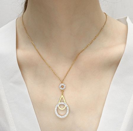 Close-up of the gold necklace with an interlocking circle pendant adorned with clear crystals.