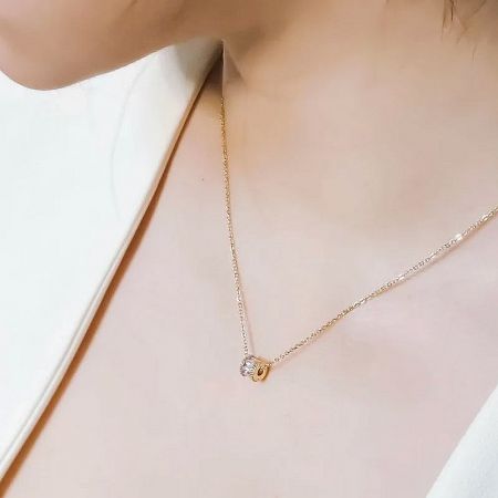 Detailed view of a gold choker with a clear gemstone pendant.