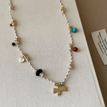 Detailed view of the natural stone beads and vintage-style horse pendant.