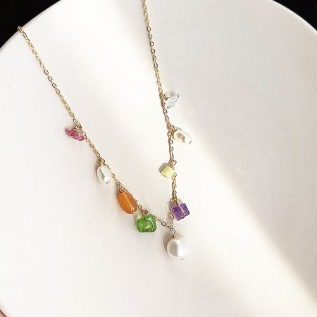 Another angle of the gold necklace with colorful stones and pearls, emphasizing its craftsmanship.