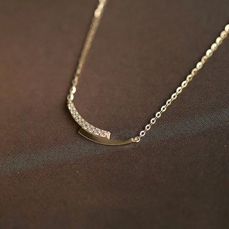 925 Silver Pavé Crystal Intersection Pendant Necklace Set of 5 - A close-up of a 925 sterling silver necklace from the pavé crystal set, featuring a gold finish and a distinctive curved pendant with sparkling crystals.