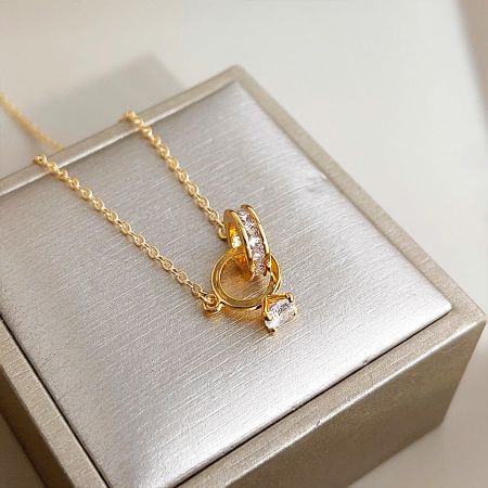 Detailed view of the zircon-adorned pendant on the gold-plated necklace.