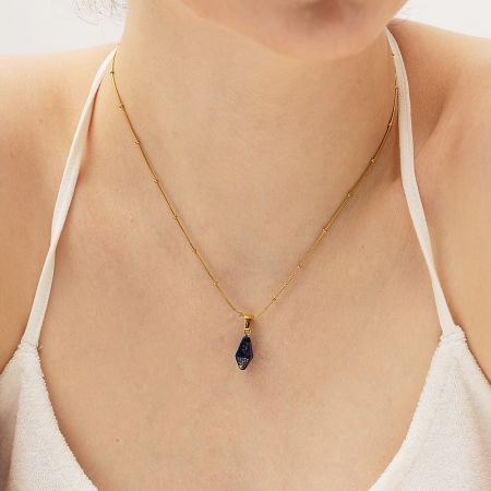 Lapis Lazuli pendant on a gold necklace, worn for an elegant look.
