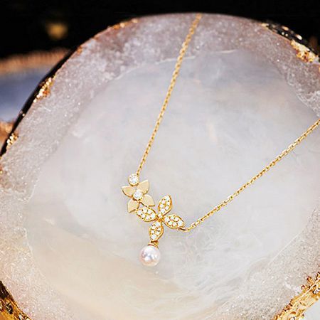 Detailed view of the zircon clover leaf pendant with a lustrous pearl on the sterling silver necklace.