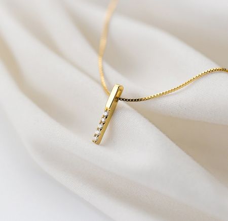 Detailed close-up of the ridged pendant with five sparkling cubic zirconia stones.