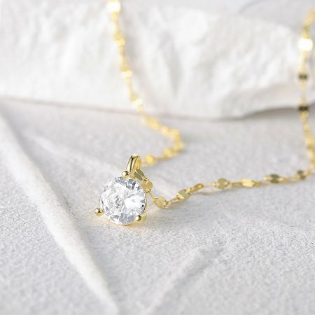 Close-up of the gold-finish single stone necklace pendant.