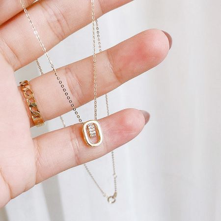 Side angle of the 925 sterling silver oval pendant necklace, emphasizing its elegant gold finish.