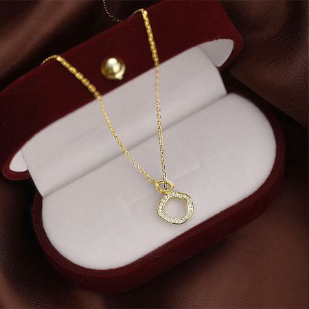 Gold necklace with a diamond pendant in a red velvet gift box.