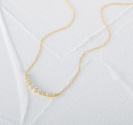 Close-up view of the CZ curved bar necklace highlighting the gemstone details.