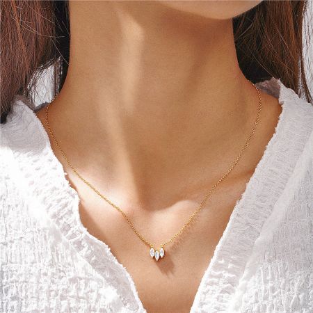 Detailed view of the double marquise-cut zircon pendant on the gold necklace.